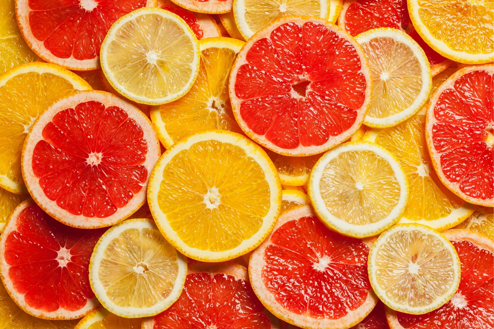 Sliced citrus fruits including grapefruits and lemons arranged together.